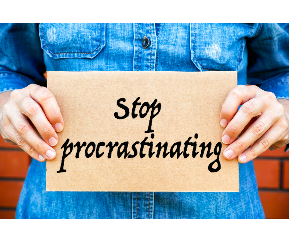 Woman holding a sign that says stop procrastinating.