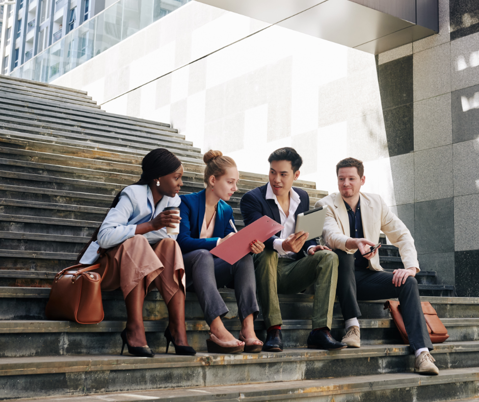 Four coworkers sitting on stairs having a conversation