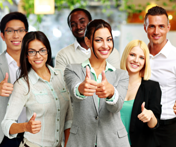 Smiling team members giving a thumbs up to their leader.