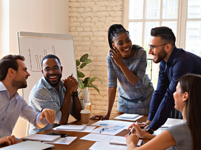 A team around a table smiling at each other and working together.