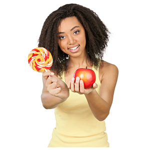 A young lady holding a lollipop in one hand and an apple in the other hand.